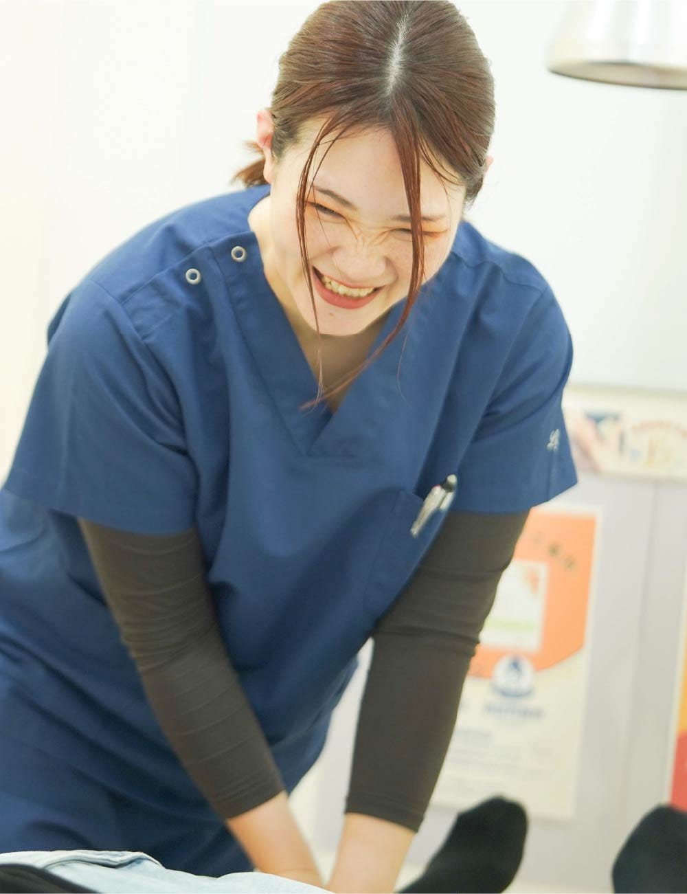 眼鏡の女性スタッフが、お客様の首まわりへ手を添えてケアしている様子